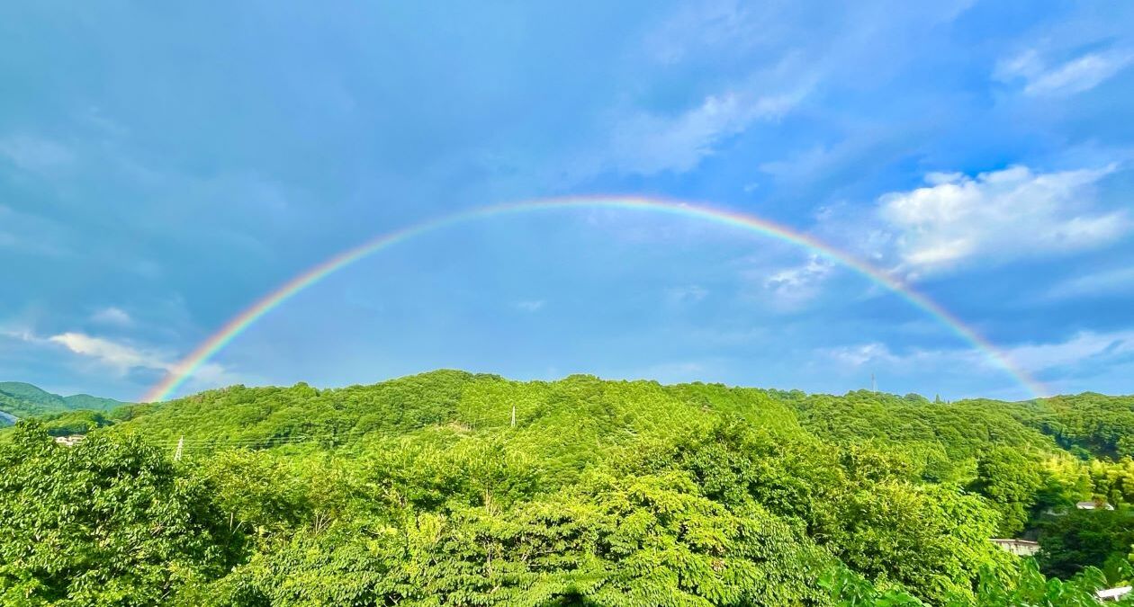 山の上にかかる虹と青空